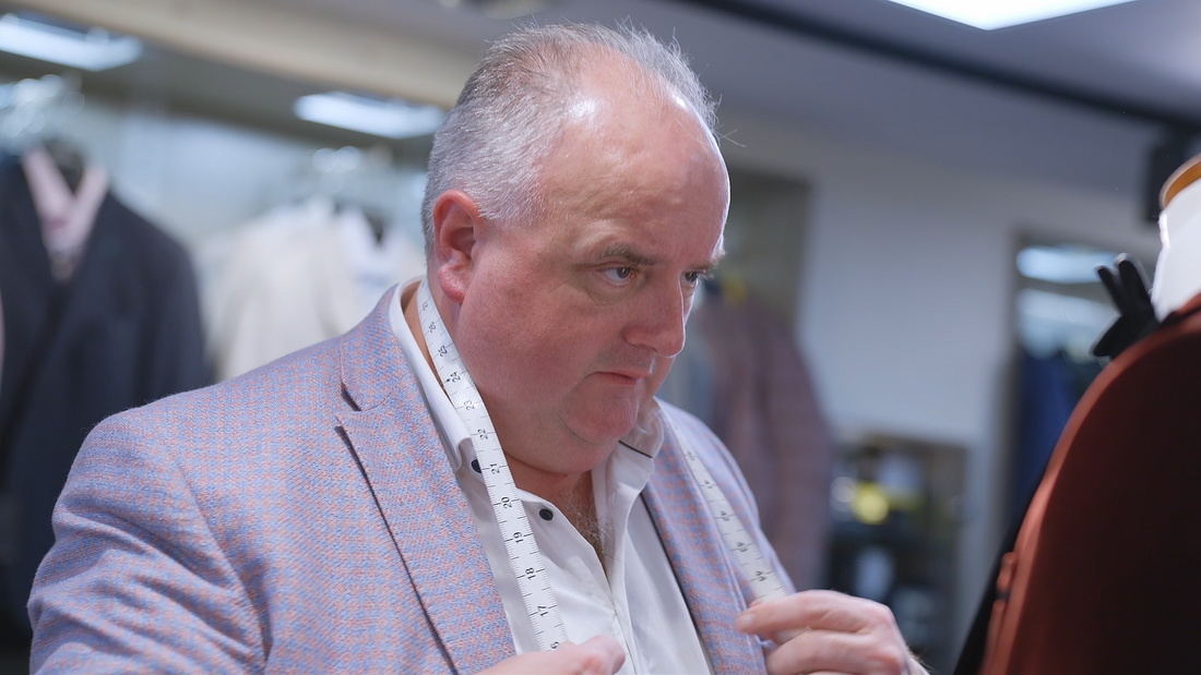 Micheal, made-to-measure fitter at Ryle Menswear, Tralee, with a tape measure
