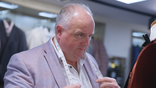 Micheal, made-to-measure fitter at Ryle Menswear, Tralee, with a tape measure