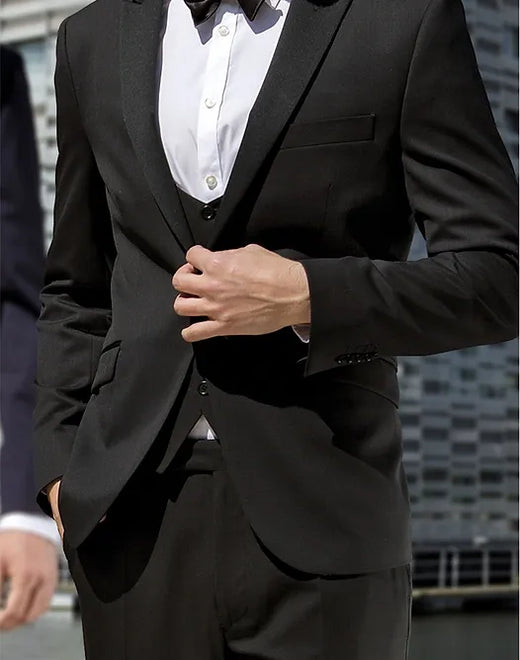 A man in a black three-piece suit and white shirt